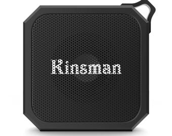 May include: A square black portable speaker with a perforated front grille. The word Kinsman is printed in white, dotted lettering across the centre. The device features a thick, angular frame and a small integrated loop at the top right corner.