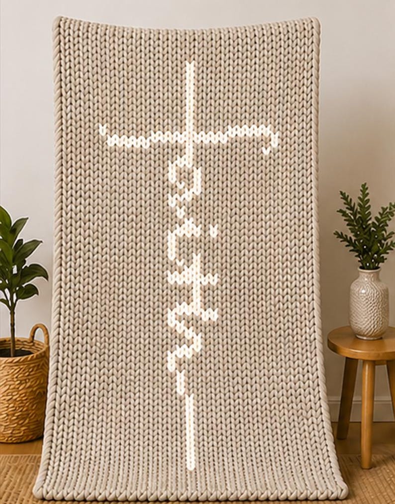 May include: A beige knitted throw blanket with the word "Faith" in white, vertically aligned, and a white cross at the top. The blanket has a thick, textured knit pattern and a rope-like border.