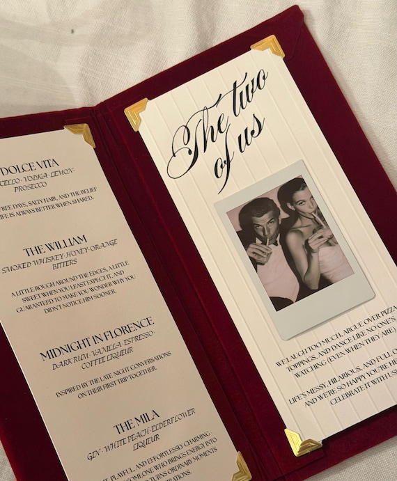 Tactile velvet wedding menus with a custom Polaroid photo panel — a genuinely elevated table detail that feels designer, not DIY-basic.
