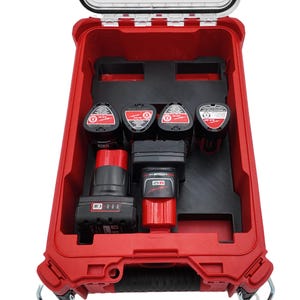 May include: A red tool case with a clear lid, open to reveal black inserts holding multiple black and red power tool batteries and tools. The case is designed to organize and protect the tools.