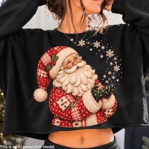 Puede incluir: Una sudadera negra de manga larga con un estampado gráfico de Santa Claus con un gorro y abrigo de estilo patchwork en rojo y blanco. Santa tiene una gran barba blanca y está rodeado por un rastro de copos de nieve blancos sobre la tela.