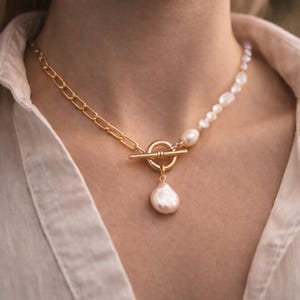 May include: A set of three ceramic mugs with a speckled, matte finish. The mugs are in shades of cream, light gray, and dark gray. Each mug has a simple, minimalist design, perfect for coffee or tea.