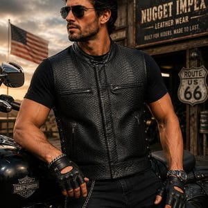 May include: A black sleeveless vest featuring a textured snakeskin pattern, a mandarin collar, and two horizontal zippered chest pockets. The vest is constructed with a front zipper closure and side lacing details, providing a structured fit.