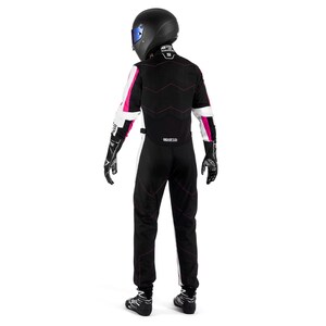 May include: A black racing suit with white and pink accents, worn with a black helmet and gloves. The suit features pink stitching and the Sparco logo. The person is wearing black racing shoes.