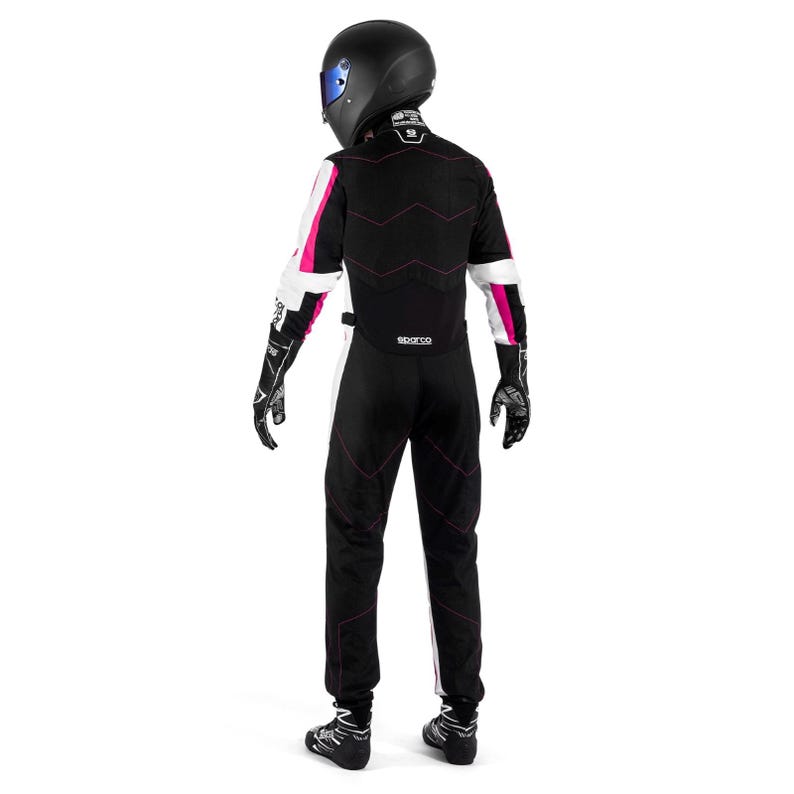 May include: A black racing suit with white and pink accents, worn with a black helmet and gloves. The suit features pink stitching and the Sparco logo. The person is wearing black racing shoes.