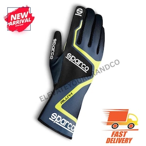 May include: A Sparco Rush racing glove in black, navy blue, and yellow. The glove features the Sparco logo and the word "RUSH". The glove is designed for racing and has a textured grip.