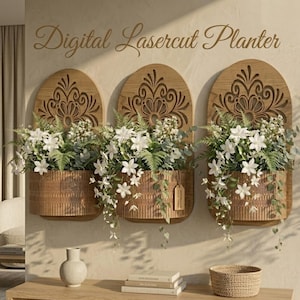 Peut inclure: Trois jardinières murales en bois avec des motifs découpés au laser, remplies de fleurs blanches et de verdure. Les jardinières sont de couleur bois chaleureuse, créant un aspect rustique et élégant. Le texte "Digital Lasercut Planter" est au-dessus des jardinières.