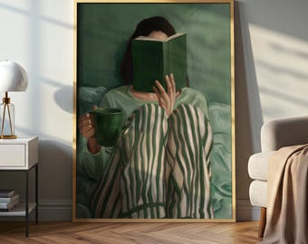 May include: A framed artwork shows a person reading a book, holding a green mug. The person wears a green top and striped green and white pyjama bottoms. The artwork is in a gold frame and has a green background.