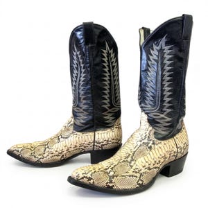 May include: A pair of cowboy boots with a snakeskin pattern on the lower part and black leather uppers. The boots have decorative stitching in silver and a pointed toe. The heels are approximately 2 inches high.