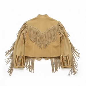 May include: Tan suede jacket with long fringe detailing on the sleeves, back, and cuffs. The jacket features silver-tone stud accents along the shoulders and cuffs. A classic Western-inspired design.
