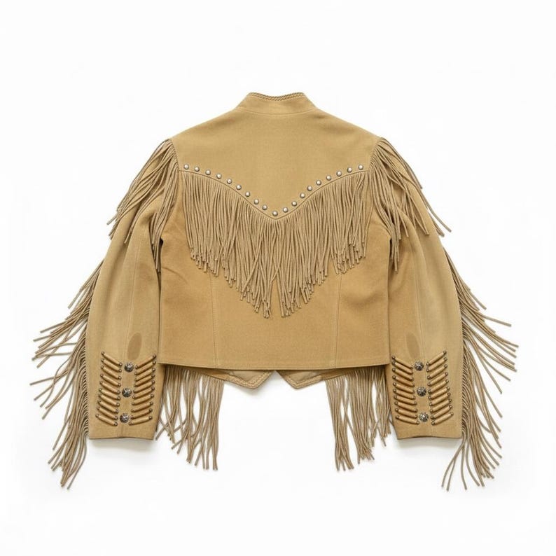 May include: Tan suede jacket with long fringe detailing on the sleeves, back, and cuffs. The jacket features silver-tone stud accents along the shoulders and cuffs. A classic Western-inspired design.