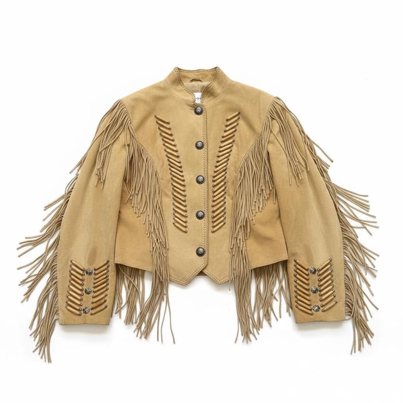 May include: A tan suede jacket with long fringe detailing on the sleeves and back. The jacket features decorative stitching and silver-tone buttons down the front. A classic western-inspired garment.