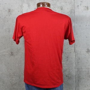 May include: A solid red t-shirt with short sleeves, displayed on a mannequin. The shirt is made of a soft material and has a classic crew neck. The back of the shirt is visible, showing the simple design.