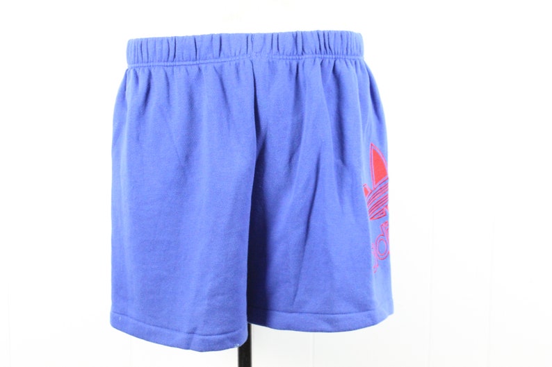 May include: Blue athletic shorts with a red Adidas logo on the right leg.