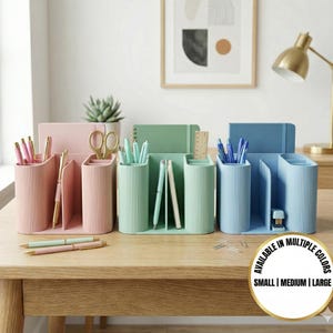 May include: Desk organizers in pink, green, and blue, each with multiple compartments for pens, pencils, and other office supplies. The organizers are ribbed and have a modern design. The image also includes pens, scissors, and notebooks. The text on the image says "AVAILABLE IN MULTIPLE COLORS" and "SMALL | MEDIUM | LARGE".