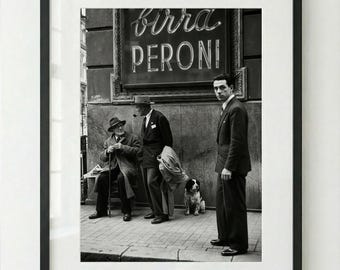 Può includere: Stampa in bianco e nero incorniciata di una scena di strada. Tre uomini e un cane sono presenti. Un'insegna al neon sopra recita "Birra Peroni". È una fotografia d'epoca.