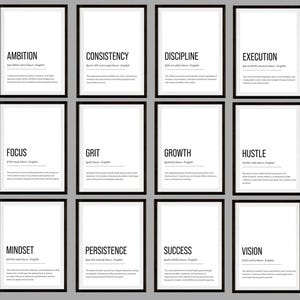 Op de afbeelding: Een set van twaalf ingelijste motivatieposters. Elke poster toont een woord als "Ambition" of "Vision" in vette tekst, samen met de definitie. De posters hebben zwarte lijsten met een witte achtergrond.