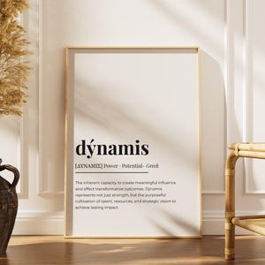 Könnte beinhalten: Ein gerahmter Druck mit dem Wort "dýnamis" in einer eleganten Schriftart. Die griechische Definition des Wortes ist darunter abgedruckt. Der Rahmen hat eine hellgoldene Farbe, und der Hintergrund ist ein weiches Off-White. Der Druck wird in einem gut beleuchteten Raum gezeigt.
