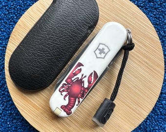 Navaja suiza Victorinox Classic SD Lobster – Edición limitada de la serie de verano de 58 mm, diseño descatalogado, artículo EDC de colección, con funda de cuero y cordón.
