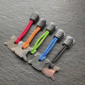 Könnte beinhalten: Fünf Multi-Tool-Schlüsselanhänger mit farbigen Kordeln in Rot, Orange, Grün, Blau und Schwarz. Jeder Schlüsselanhänger hat ein Metallwerkzeug mit dem eingravierten Markennamen "Victorinox" und eine schwarze Kunststoffkappe.