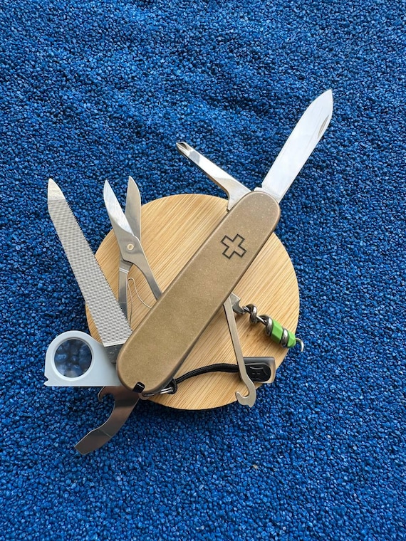 A craftsperson hand-modded a classic Swiss Army Knife with brass scales and dark green G10 liners — turning an everyday tool into a one-of-a-kind EDC collector's piece.