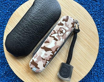 Juego de cuchillo Victorinox Classic CD de 58 mm con estampado de camuflaje desértico, funda y cordón.