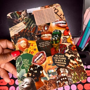 May include: A collage-style design featuring various images and text elements. The design includes portraits, lips, and text that reads "Black Girls", "Black Culture is Not a Fashion Trend", and "I love being black". The design is held over a pink and black keyboard.