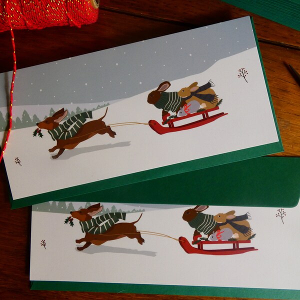 Lot de 2 cartes postales de Noël "Teckel tirant la luge des lapins".