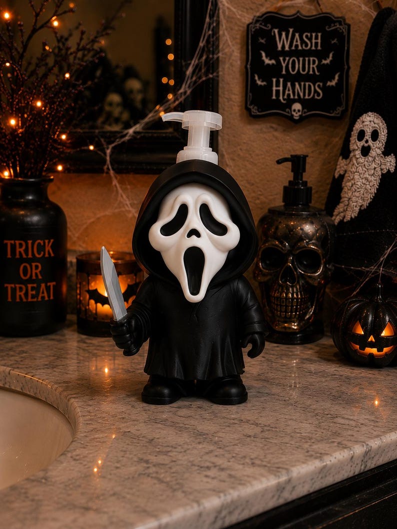 Peut inclure: Un distributeur de savon en forme de personnage v&ecirc;tu d'une robe noire &agrave; capuche et d'un masque blanc avec une bouche et des yeux allong&eacute;s. La figurine tient un couteau argent&eacute; dans sa main droite et poss&egrave;de une pompe en plastique transparent.