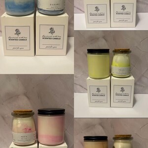 K&ouml;nnte beinhalten: Eine Auswahl an Duftkerzen in Gl&auml;sern mit Kork- oder schwarzen Deckeln, pr&auml;sentiert auf wei&szlig;en Schachteln. Die Kerzen haben verschiedene Farben, darunter Blau, Gr&uuml;n, Gelb, Rosa und Orange. Auf jeder Schachtel steht "Handmade with love Scented Candle".