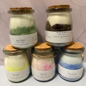 K&ouml;nnte beinhalten: F&uuml;nf Glas-Kerzen im Glas mit Korkdeckeln. Die Kerzen sind mit "Safari", "Kahawa", "Pwani", "Maua" und "Bahari" beschriftet. Jede Kerze wiegt 170 g. Die Kerzen haben verschiedene Farben, darunter Gr&uuml;n, Braun, Gelb, Rosa und Blau.