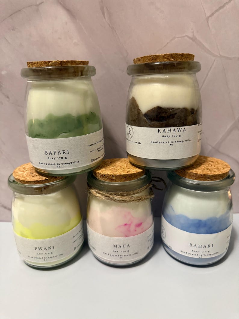 K&ouml;nnte beinhalten: F&uuml;nf Glas-Kerzen im Glas mit Korkdeckeln. Die Kerzen sind mit "Safari", "Kahawa", "Pwani", "Maua" und "Bahari" beschriftet. Jede Kerze wiegt 170 g. Die Kerzen haben verschiedene Farben, darunter Gr&uuml;n, Braun, Gelb, Rosa und Blau.