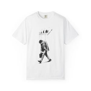 May include: A white ceramic mug with a black handle and the text "But First, Coffee" in a bold, black font. The mug is set against a blurred background, suggesting a cozy setting.