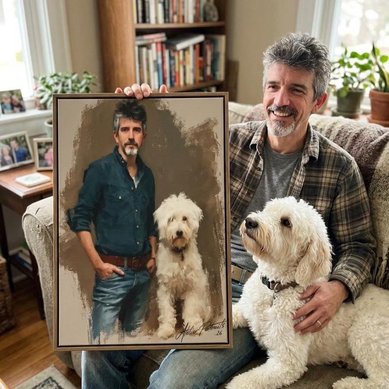 May include: A framed portrait of a man and a white dog. The painting depicts the man in a dark blue shirt and jeans, standing next to the dog. The painting is held by a man with gray hair, who is sitting next to a similar dog.