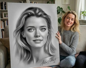 Può includere: Un ritratto in bianco e nero di una donna con lunghi capelli ondulati. L'opera d'arte è firmata "Atelier Portraits .26" in basso a destra. Il ritratto è tenuto da una persona che indossa un maglione grigio e jeans blu.