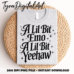 May include: A pale grey t-shirt featuring the words "A Lil Bit Emo A Lil Bit Yeehaw" in black script, with star accents. The shirt rests on a woven, circular mat. The image also includes the text "300 DPI PNG FILE - INSTANT DOWNLOAD".