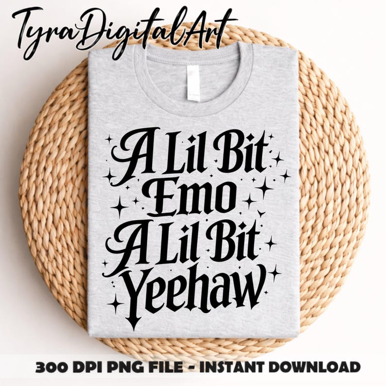 May include: A pale grey t-shirt featuring the words "A Lil Bit Emo A Lil Bit Yeehaw" in black script, with star accents. The shirt rests on a woven, circular mat. The image also includes the text "300 DPI PNG FILE - INSTANT DOWNLOAD".