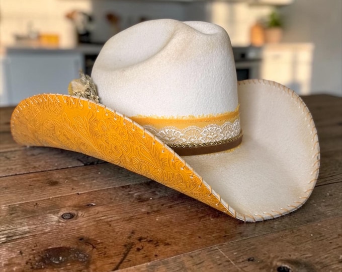 100% wool ivory cowboy hat with marigold tooled leather handstitched to brim.