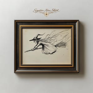 May include: A framed ink sketch titled Signature Atlas Sketch featuring a black line drawing of a figure in a pointed hat riding a broomstick. The artwork is encased in a dark brown wooden frame with gold inner trim, set against a light wall.