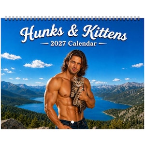 May include: A 2027 wall calendar titled Hunks & Kittens featuring a shirtless person with long brown hair holding a tabby kitten. The background displays a scenic landscape with a blue lake, green pine trees, and mountains under a clear sky.
