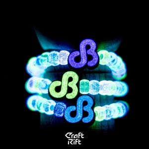 May include: Three stacked bracelets made of round, textured beads that glow in the dark. Each bracelet features a central charm shaped like a stylized letter B, with one charm glowing purple, one green, and one blue against a dark background.