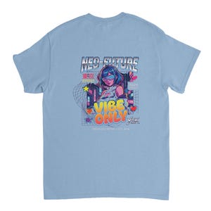 Könnte beinhalten: Ein hellblaues T-Shirt mit einem Grafikdruck auf der Rückseite. Das Design zeigt eine stilisierte Figur mit blauem Haar, Neon-Stadt-Elementen und den Text NEO-FUTURE, VIBE ONLY, TOKYO STREET, 2026 TRENDS, Y2K und URBAN COLLECTIVE / EST. 2026.