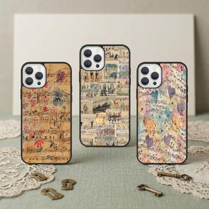 May include: Three phone cases with black edges. Each case has a different design: one with sheet music and floral details, another with a collage of illustrations, and the third with watercolour hearts and musical notes. The cases are on a green surface.