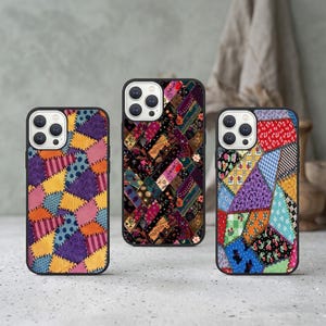 May include: Three phone cases with black surrounds and vibrant patchwork patterns. The cases display diverse designs, including floral, geometric, and abstract shapes in red, purple, yellow, and blue. The cases are designed to fit a smartphone.