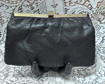 1960s Etra black leather clutch with gold-tone bar clasp, metal frame, and tuckable chain strap
