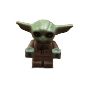 Peut inclure: Une petite figurine en plastique vert avec de grandes oreilles pointues, des yeux sombres et un torse beige orné d'un motif graphique noir. Le personnage possède une tête moulée avec des lignes visibles et deux petits bras aux mains ouvertes.