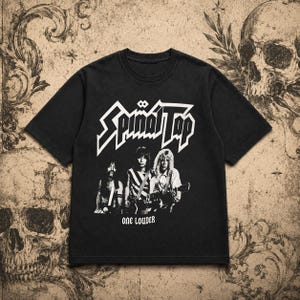 May include: A black short-sleeved t-shirt featuring a white graphic print of the band Spinal Tap. The design includes the band name in a stylised font above a black and white photograph of three musicians and the text ONE LOUDER at the bottom.