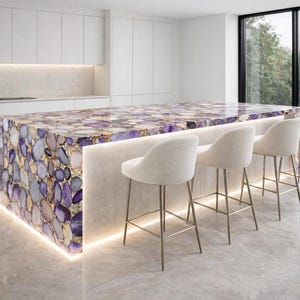 Isola cucina in agata ametista con delicata illuminazione a LED, piano in lastra di cristallo viola, elemento d'arredo di lusso su misura.