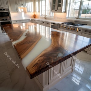 Peut inclure: Un îlot de cuisine sur mesure avec un plan de travail en bois à bord brut. Le plan de travail présente une rivière de résine époxy blanche traversant le centre du bois. L'îlot a une base d'armoire blanche.