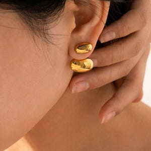 May include: A white ceramic mug with a black handle and the text "But First, Coffee" in a handwritten style. The mug is on a white surface. The mug is likely for hot beverages.